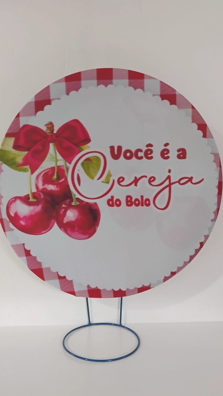 Painel de referência Você é a Cereja do Bolo: a frase “Você é a Cereja do Bolo”, duas cerejas e uma borda xadrez rosa e branca.