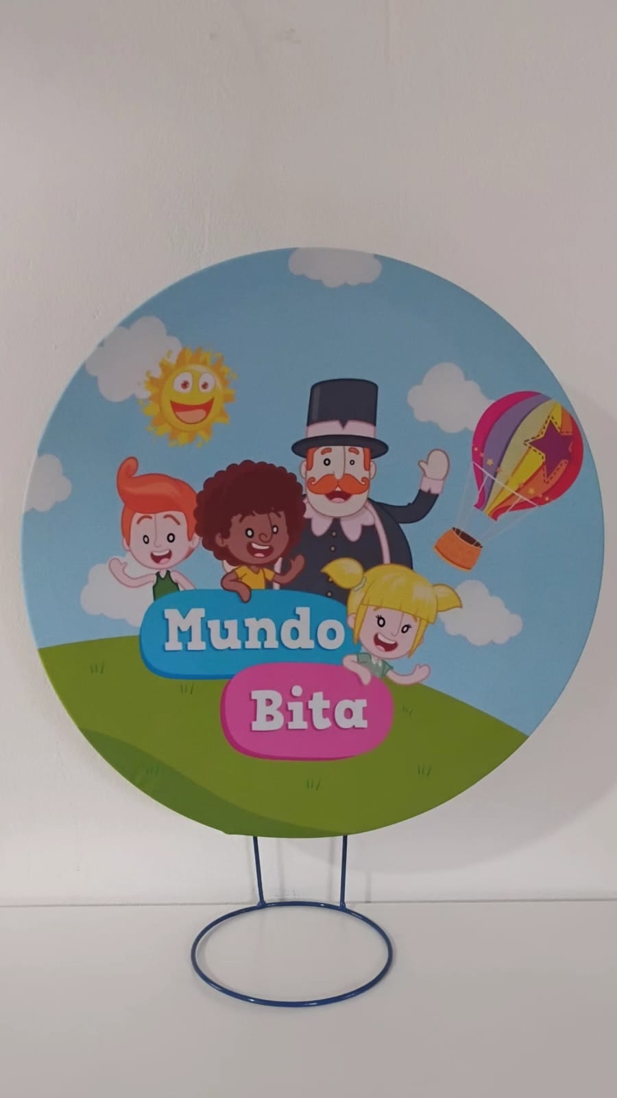 Painel de referência Mundo Bita: o nome Mundo Bita e personagens coloridos em uma paisagem com arco-íris.